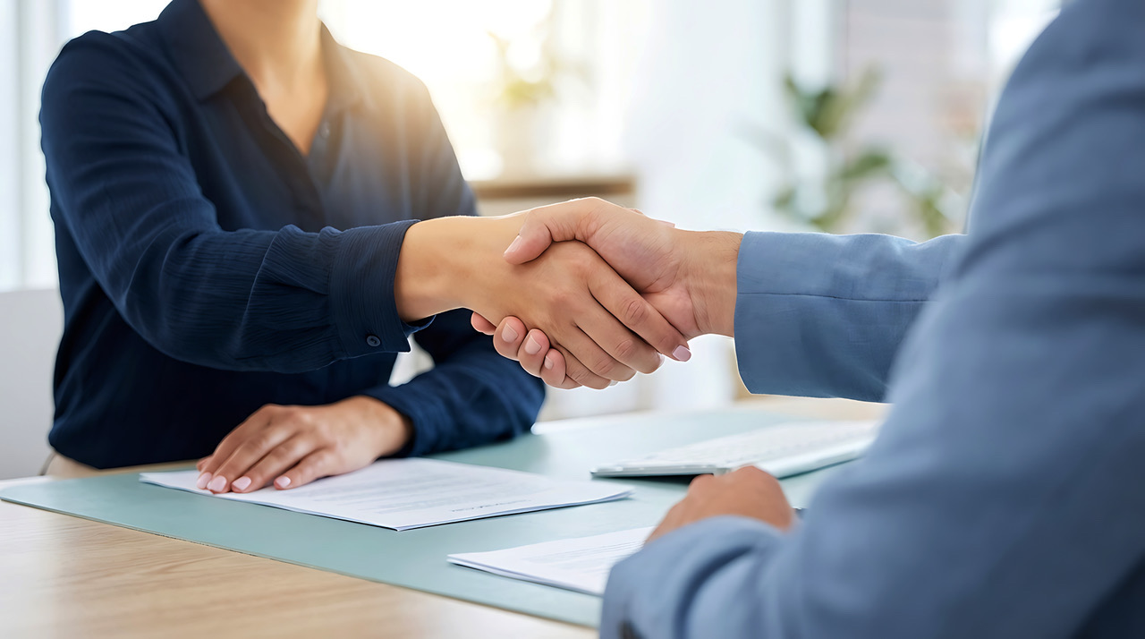 Compliance consultant shaking hands with a client after a successful BSA/AML consultation
